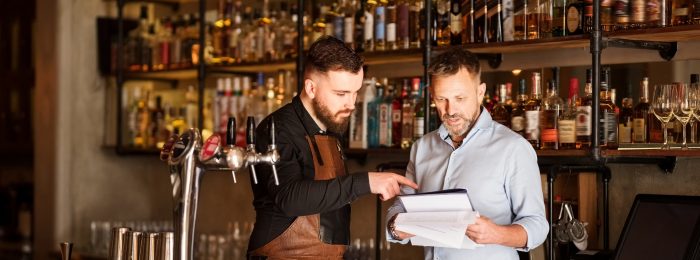 Shot of a bar manager and bartender checking the stock in the pub